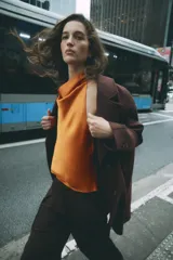 Abrigo largo de Zara confeccionado en hilatura con lana, de color marrón oscuro. Cuenta con cuello solapa, manga larga, bolsillos de vivo en el delantero y cierre frontal con dos botones.