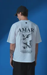 Remera blanca de corte oversize con cuello redondo y manga corta. Presenta una estampa gráfica en la espalda con diseño de palomas, flores y texto en español.