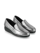 Mocasines slip-on de cuero metalizado color plateado, con suela anatómica de goma negra en bloque.