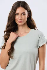 Remera de algodón color verde menta, con escote redondo y mangas corta con detalles de volados sutiles en los puños.
