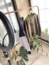 Buzo cropped de algodón color verde militar, con mangas ranglan y diseño estampado en el frente con motivos de besos y moños. Cuenta con elástico holgado en la cintura y los puños.