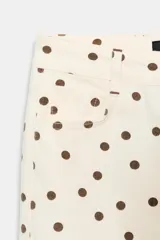 Jeans de tiro medio con diseño de cinco bolsillos, corte mini flare y bajo evasé. Presenta un estampado de lunares en contraste.