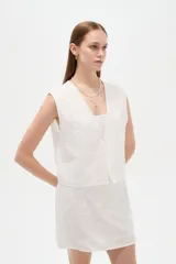 Chaleco blanco sin mangas confeccionado en algodón, con cuello en V y diseño bordado.