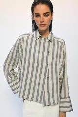 Camisa de corte oversize confeccionada en mezcla de viscosa, con estampado de rayas verticales. Presenta cuello solapa, cierre frontal con botones y mangas largas con puños amplios.