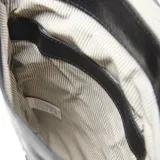 Mochila de cuero negro con textura granulada, diseño de solapa con cierre de hebilla metálica ajustable y logo de la marca grabado en el frente.