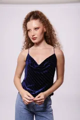 Top negro de terciopelo con breteles finos y escote en V. Presenta líneas verticales de lentejuelas plateadas.