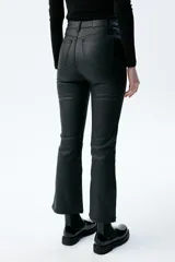 Pantalón de jean negro de tiro medio/alto con silueta levemente acampanada desde la rodilla.