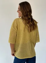 Camisa de punto calado color pistacho con hilos de lurex. Posee cuello camisero, botones frontales, mangas cortas y bolsillos delanteros.