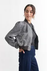 Campera bomber gris de cuero sintético con cuello, puños y ruedo acanalados.