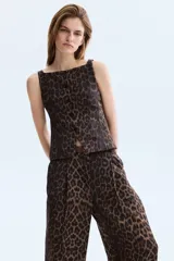 Pantalón amplio de tiro alto confeccionado en mezcla de viscosa, con estampado animal print de leopardo, pinzas delanteras y traseras, y diseño de pernera ancha. Incluye un cinturón delgado de cuero marrón con hebilla metálica.