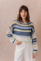 Buzo tejido de punto calado con rayas horizontales multicolor en tonos azul, amarillo, celeste y blanco, con escote bote, mangas largas y hombros caídos. Incluye top básico al tono.