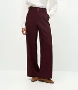 Pantalón wide leg de cintura alta, confeccionado en una mezcla de viscosa y poliéster. Presenta cierre frontal con dos botones, trabillas para cinturón y bolsillos laterales.