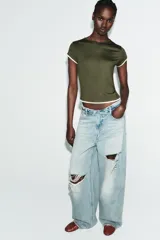 Camiseta de corte slim fit, color verde militar, con cuello redondo y manga corta. Presenta vivos de contraste blancos en el ruedo de las mangas y en el bajo.