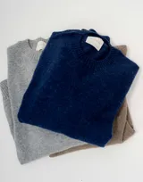 Sweater gris de corte clásico, cuello redondo y tejido liviano de baby alpaca.