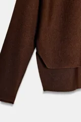 Jersey de punto con cuello redondo y manga larga, diseñado con un cuerpo amplio estilo capa y sisa ancha.
