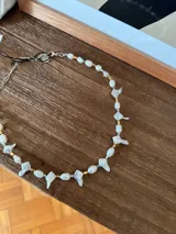Collar corto de perlas de río y perlas barrocas con formas irregulares, intercaladas con pequeñas piezas metálicas en tonos dorado y plateado. Cuenta con cadena de extensión para regular el largo.