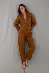Pantalón sastrero de lino color tostado, con tiro medio, corte flojo que se afina suavemente hacia los tobillos y bolsillos delanteros verticales con vivos decorativos.