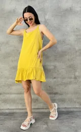 Vestido corto amarillo con breteles finos y falda con volados.