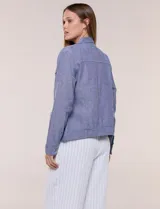 Camperita de lino liviana, marca Dash, con estampado botánico de hojas en tonos azules, verdes y tostados sobre base blanca. Presenta cierre frontal con botones, cuello clásico y bolsillos aplicados en el pecho.