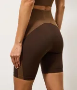 Bermuda deportiva Get Over de microfibra seamless, en color marrón con recortes contrastantes en tono tostado. Presenta cintura alta con pretina ancha cruzada y diseño ajustado.