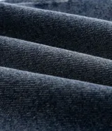 Pantalón de jean corte slim color azul claro con efecto de lavado desgastado. Cuenta con cierre frontal con botón, pasadores para cinturón y bolsillos funcionales.