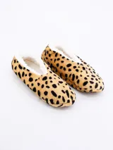 Pantuflas tipo ballerina con interior de felpa blanca y exterior de tela con estampado de leopardo.