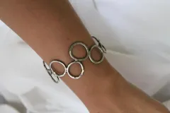 Pulsera rígida plateada hecha en alpaca, con diseño de eslabones circulares.