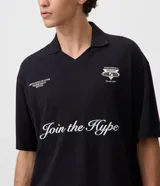 Remera de algodón para hombre con diseño boxy, cuello polo y escote en V. Presenta mangas cortas y estampas localizadas en el frente, incluyendo la frase 'Join the Hype'.