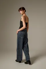 Body negro con tirantes finos, escote en V pronunciado y corte ajustado al cuerpo, con detalles bordados sutiles.
