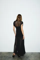 Vestido midi negro de cuello alto y sin mangas, con detalle drapeado en la parte superior y falda plisada. Incluye forro interior con tirantes finos ajustables y cierre lateral con cremallera oculta.
