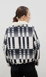 Campera con estampado de bosque en tonos azules, cuello de sherpa en color crema y cierre frontal con cremallera. Cuenta con elástico ajustable en la cintura.