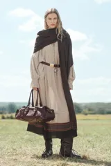 Bolso de hombro alargado de piel color borgoña con doble asa, detalles y hebillas metálicas doradas, charm de espejo colgante y bolsillos laterales exteriores.