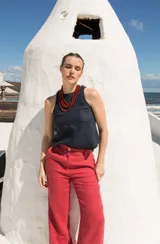 Top sin mangas de lino, con cuello redondo y cierre posterior mediante tres lazos. Diseño minimalista y versátil.