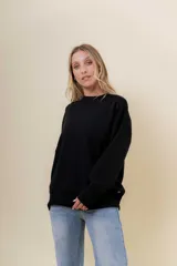 Sweater de tejido fino color beige, con cuello redondo, mangas largas y terminaciones acanaladas. Presenta un diseño con detalles trenzados en diagonal en el frente y corte relajado.