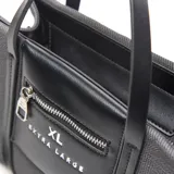 Cartera chica tipo tote de lona gris con detalles en cuero sintético negro, doble asa de mano y bolsillo frontal con cierre y el logo de la marca Extra Large.