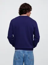 Buzo deportivo Gap color crudo, de corte recto, con cuello redondo y logo Gap NYC estampado en verde.