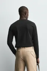Camiseta slim fit de manga larga y cuello redondo, confeccionada en tejido de algodón elastizado de color marrón oscuro.
