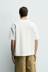 Sudadera de corte relajado confeccionada en tejido técnico interlock con mezcla de algodón, cuello redondo y manga corta.