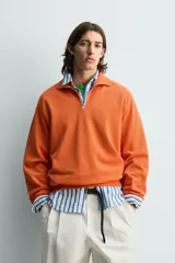 Sudadera regular fit azul marino confeccionada en tejido de algodón con estructura piqué. Cuenta con cuello subido, cierre frontal de cremallera corta y mangas largas con acabados en rib.
