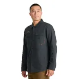 Campera tipo camisa de trabajo Roark, confeccionada en lona de algodón orgánico color gris oscuro. Presenta cierre frontal con botones a presión, dos bolsillos frontales con solapa, paneles reforzados en los codos y detalles bordados sutiles en el pecho y la manga.