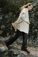 Poncho de tejido de punto color caramelo con cuello alto y diseño holgado sin mangas.