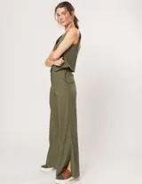 Pantalón palazo verde militar de lino con tiro alto, elástico en la pretina trasera, cierre delantero, bolsillos laterales y tajos a los costados.