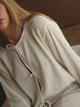 Saco de tejido de punto color azul marino, con escote en V y cierre frontal de botones.