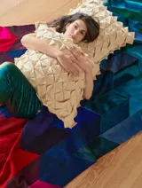 Almohadón cuadrado de lana color beige, con diseño geométrico en relieve. Relleno con funda de algodón, guata y restos textiles.