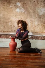 Top corto de tul estampado con diseño abstracto en tonos azul, rojo y negro, de mangas largas y corte ajustado.