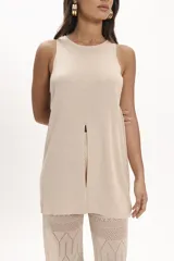 Blusa beige de tejido de punto con cuello redondo y sin mangas. Presenta un tajo central en el frente.