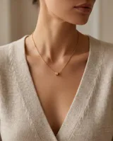 Collar de cadena fina con dije de cubo pequeño en color dorado.