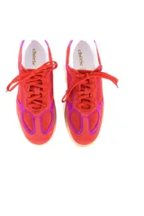 Championes de estilo retro con diseño deportivo, confeccionados en cuero vacuno y gamuza en tonos rojo y fucsia. Presentan cordones al tono, suela plana de goma en color caramelo y detalle de marca bordado en dorado en el lateral.