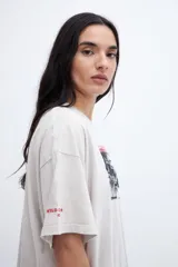 Remera gris con efecto marmolado, calce boxy, diseño fotográfico y texto en el frente.