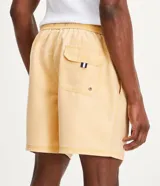 Bermuda de baño de microfibra color amarillo con efecto lavado, cintura elástica con cordón de ajuste y bolsillos laterales y traseros.